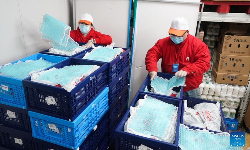 Supermarket workers cover vegetable packages with ice bags at Suzhou Industrial Park in Suzhou, east China's Jiangsu Province, Feb. 20, 2022.Photo:Xinhua