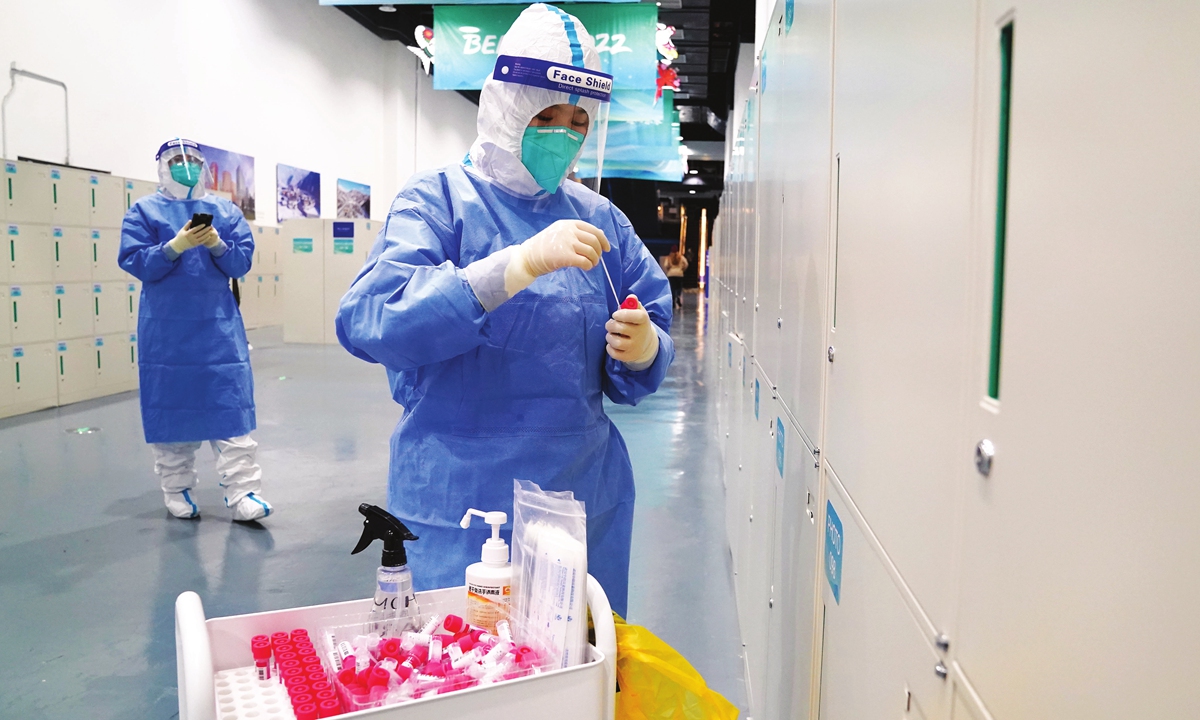 Members of staff wearing personal protective equipment take swab samples off lockers in the media center on February 3, 2022. Photo: VCG