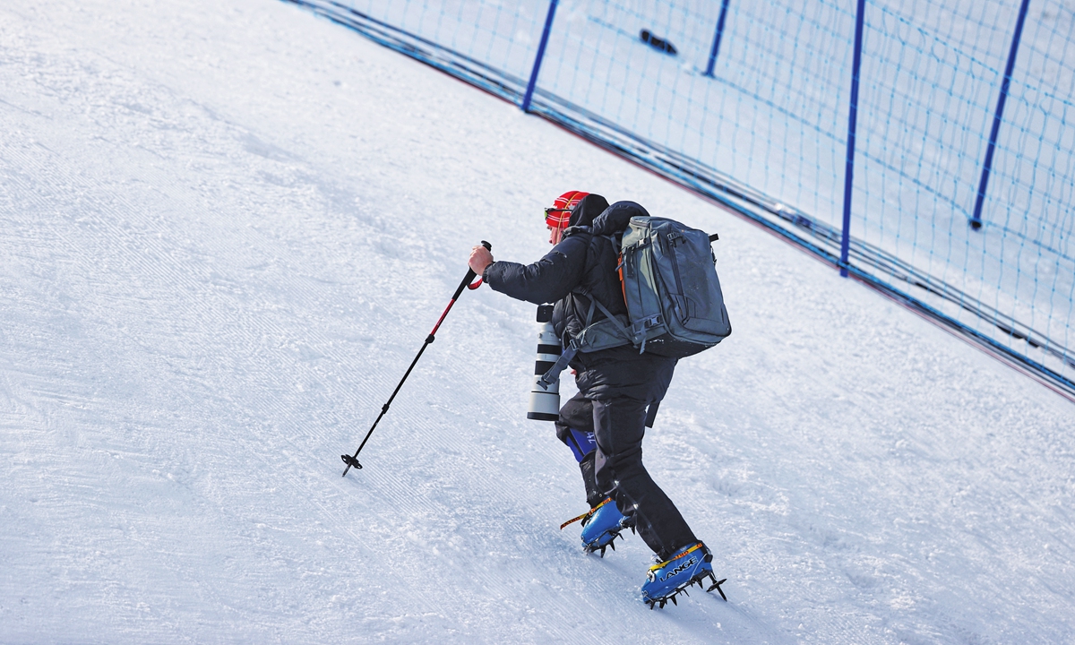 A photographer climbs to the photo position at the freestyles skiing halfpipe venue. Photo: Cui Meng/GT
