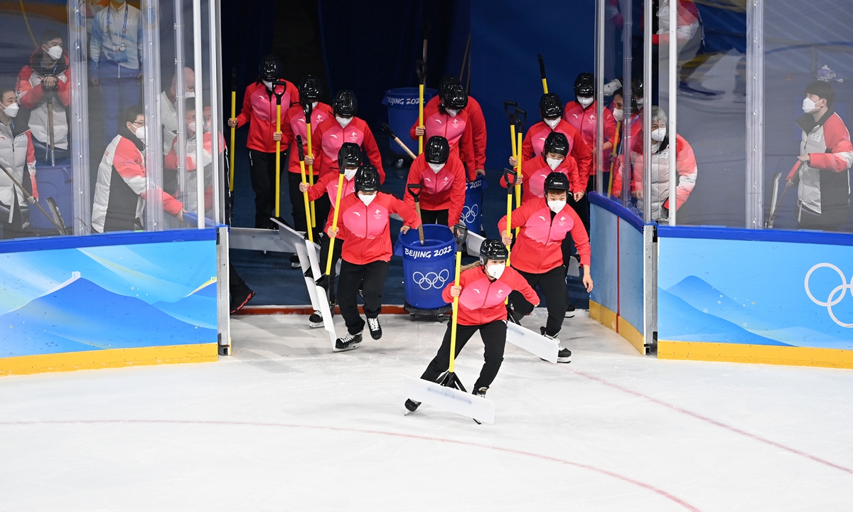 Volunteers clean the ice rink during an ice hockey competition in Wukesong Arena on February 12, 2022. Photo: VCG