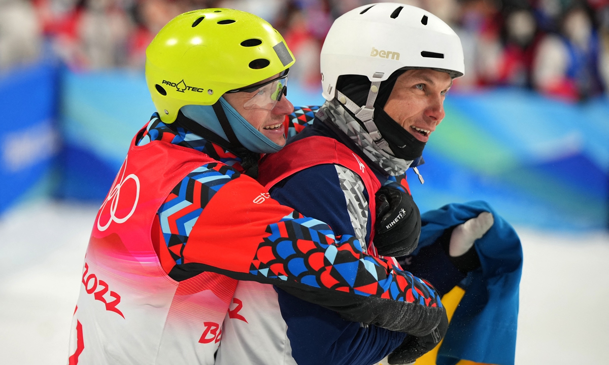 Silver medalist Ukraine's Oleksandr Abramenko (right) and bronze medalist Russian Olympic Committee's Ilia Burov celebrate after the men's freestyle skiing aerials final 2 during the Beijing 2022 Winter Olympic Games at the Genting Snow Park A & M Stadium in Zhangjiakou, China. Photo: AFP