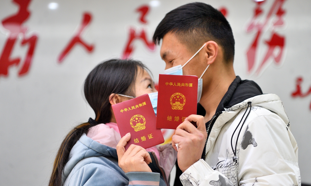 A couple poses for a photo after receiving their marriage certificate at the marriage registration office of a civil affairs bureau in Xiangyang, Central China's Hubei Province on February 22, 2022. Photo: VCG