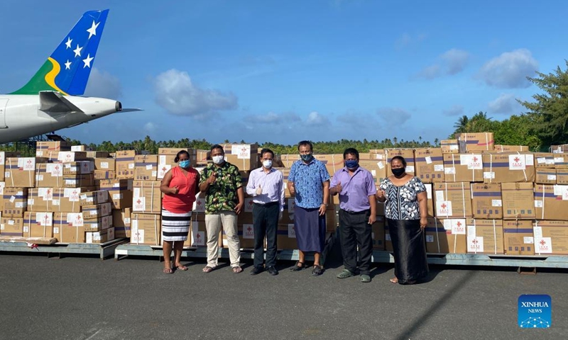 Chinese Ambassador to Kiribati Tang Songgen (3rd, L) and Kiribati Minister of Health and Medical Services Tinte Itinteang (4th, L) pose for a group photo in front of the anti-epidemic supplies at the airport in Tarawa, Kiribati, Feb. 23, 2022.(Photo: Xinhua)