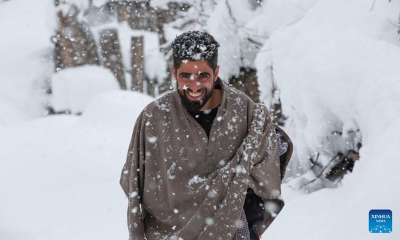 A man walks amid heavy snowfall at a village in Sursyar area of Budgam district near Srinagar, Indian-controlled Kashmir, Feb. 23, 2022.(Photo: Xinhua)