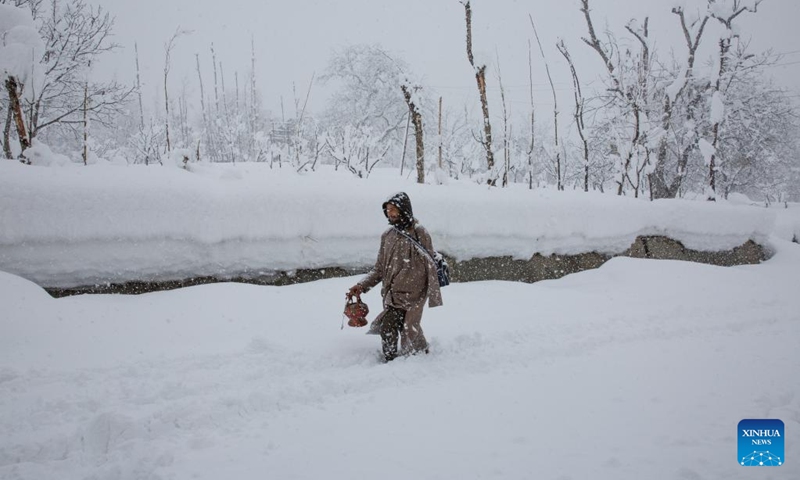 A man walks amid heavy snowfall at a village in Sursyar area of Budgam district near Srinagar, Indian-controlled Kashmir, Feb. 23, 2022.(Photo: Xinhua)
