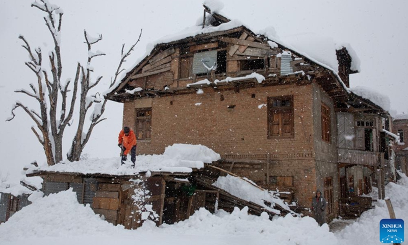 A man removes snow from the rooftop of his house amid heavy snowfall at a village in Sursyar area of Budgam district near Srinagar, Indian-controlled Kashmir, Feb. 23, 2022.(Photo: Xinhua)