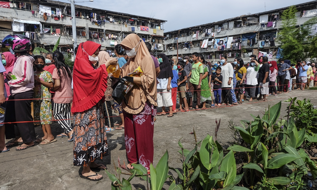 People queue to buy cooking oil at affordable prices in Palembang, Indonesia on February 24, 2022, following the shortage of crude palm oil in the country due to escalating tensions in Ukraine that pushed up crude oil prices, reflected on palm oil and soybean oil prices across the world. Photo: AFP