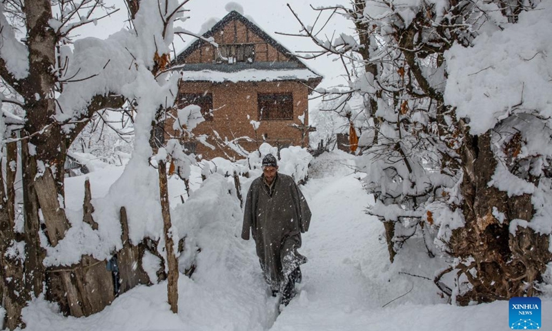 A man walks amid heavy snowfall at a village in Sursyar area of Budgam district near Srinagar, Indian-controlled Kashmir, Feb. 23, 2022.(Photo: Xinhua)