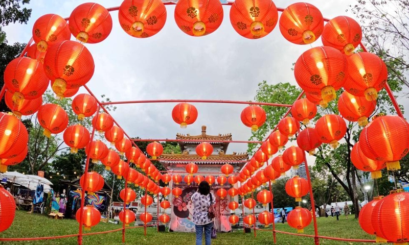 A visitor takes photos of the miniature of a building from Songkhla Province during the 40th Thailand Tourism Festival at Lumpini Park in Bangkok, Thailand, Feb. 22, 2022. The Tourism Authority of Thailand (TAT) held the 40th Thailand Tourism Festival at Bangkok's Lumpini Park, showcasing famous landmarks, local customs, cultural heritage and local specialties from five regions of Thailand. (Photo: Xinhua)