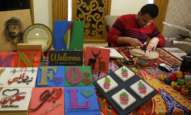 Picture taken on Feb. 24, 2022 shows Palestinian artist Naim Maarouf creating a pin-and-thread artwork at his house in Gaza City.Photo:Xinhua