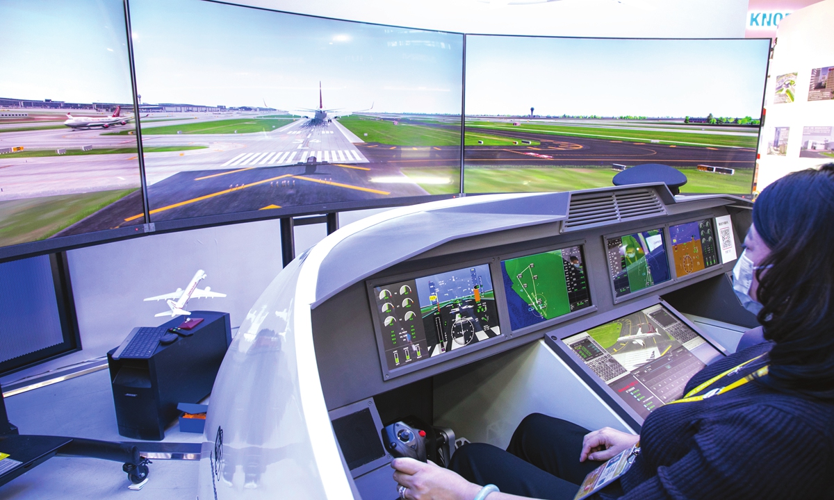 A visitor experiences simulated airliner driving at Honeywell's booth during the fourth China International Import Expo in 2021. Photo: VCG