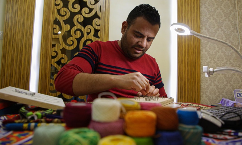 Picture taken on Feb. 24, 2022 shows Palestinian artist Naim Maarouf creating a pin-and-thread artwork at his house in Gaza City.Photo:Xinhua