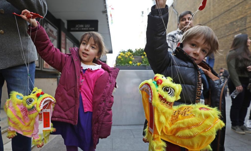 Children show dance lion souvenirs after the screening of Chinese animation I Am What I Am in London, Britain, on Feb. 26, 2022.Photo:Xinhua