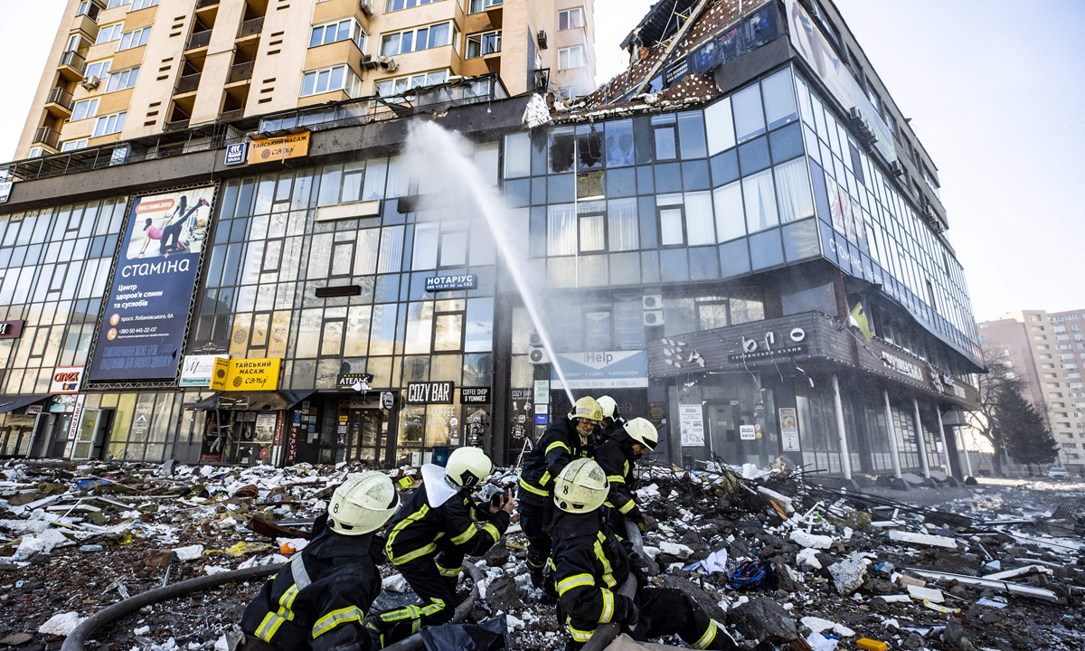 Firefighters work by a damaged apartment building in Kyiv which was hit by a recent shelling during Russiaa??s military intervention in Ukraine, on February 26, 2022. Photo: IC