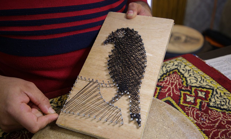 Picture taken on Feb. 24, 2022 shows Palestinian artist Naim Maarouf finishing a pin-and-thread artwork at his house in Gaza City.Photo:Xinhua