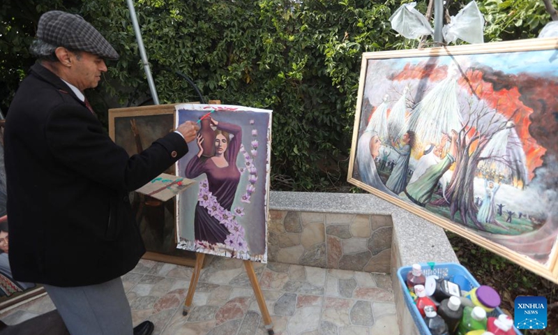 Murshid Gharib, a 73-year-old painter from Jenin who has about 50 years of experience in painting murals, works on a painting at his house in the West Bank city of Jenin, Feb. 21, 2022. TO GO WITH Feature: Palestine artists turn walls into canvas for hope(Photo: Xinhua)