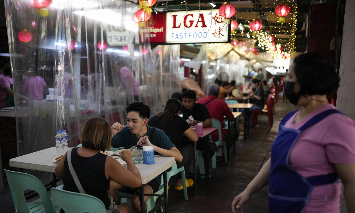 Customers eat without the usual plastic barriers on tables as the government places the capital on the lowest rung of a five-step COVID-19 pandemic alert system in Manila, the Philippines on March 1, 2022. Photo: VCG