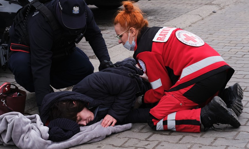 A fainted woman receives help at the Przemysl railway station in Przemysl, Poland, Feb. 27, 2022. Recently, a large number of Ukrainian people arrived in Przemysl by train.(Photo: Xinhua)