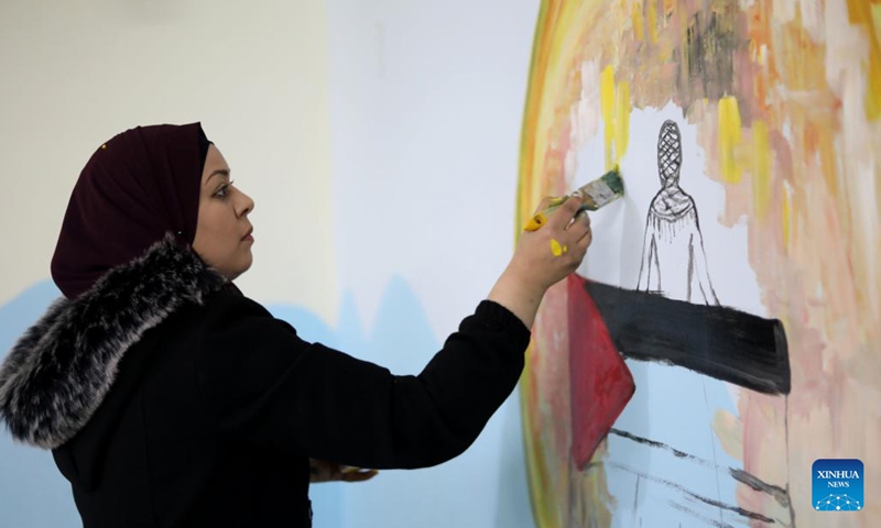 Taghreed Abu Shehab, an artist from Jenin, paints on a wall of a kindergarten in the West Bank city of Jenin, Feb. 20, 2022. TO GO WITH Feature: Palestine artists turn walls into canvas for hope(Photo: Xinhua)