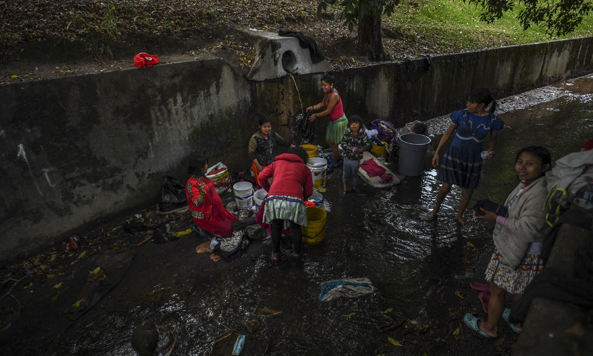 Embera indigenous people wash clothes in a makeshift camp at a national park in Bogota, Colombia on February 7, 2022. Photo: AFP