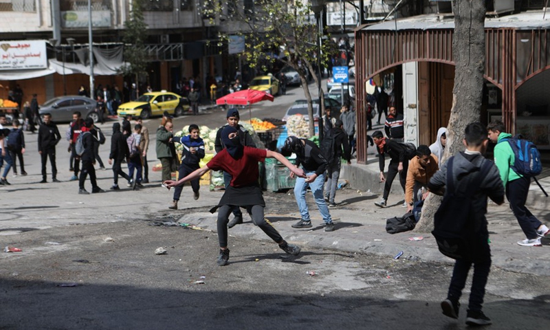 Palestinian protesters hurl stones at Israeli soldiers during clashes in the West Bank city of Hebron, on March 1, 2022.(Photo: Xinhua)