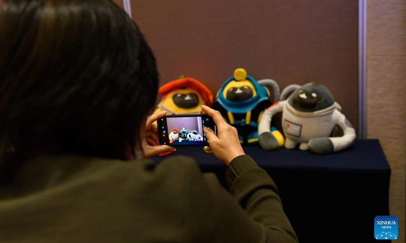 A visitor takes photos of the mascots for the 2022 China International Consumer Products Expo, styled after the Hainan gibbon, in Haikou, south China's Hainan Province, March 1, 2022. Hainan gibbons are the most endangered of all gibbons and the world's rarest primate. They are endemic to the southern Chinese island of Hainan.(Photo: Xinhua)