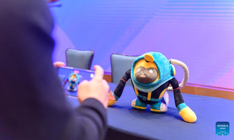 A visitor takes photos of the mascots for the 2022 China International Consumer Products Expo, styled after the Hainan gibbon, in Haikou, south China's Hainan Province, March 1, 2022. Hainan gibbons are the most endangered of all gibbons and the world's rarest primate.(Photo: Xinhua)