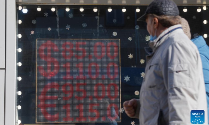 People walk past a screen of a currency exchange office displaying the exchange rates of U.S. Dollar and Euro to Russian Rubles in Moscow, Russia, March 1, 2022. Russian President Vladimir Putin signed a decree introducing temporary economic measures to ensure the country's financial stability, the Kremlin announced Tuesday.Photo:Xinhua