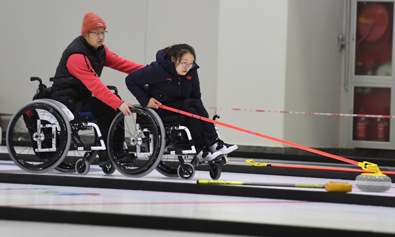 Wang Meng (R) of the Chinese national wheelchair curling team attends a training session ahead of the 2022 Beijing Paralympic Winter Games in Beijing, capital of China, Dec. 24, 2020.(Photo: Xinhua)
