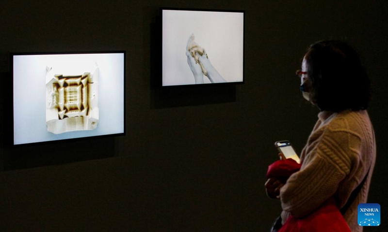 A visitor looks at works of art created using AI technology during the media preview of The Imitation Game exhibition at the Vancouver Art Gallery in Vancouver, British Columbia, Canada, March 2 2022. The exhibition, which runs from March 5 to October 23, 2022, reviews the artistic and cultural aspect by examining the use of artificial intelligence (AI) technology as a medium in the production of a form of modern art.