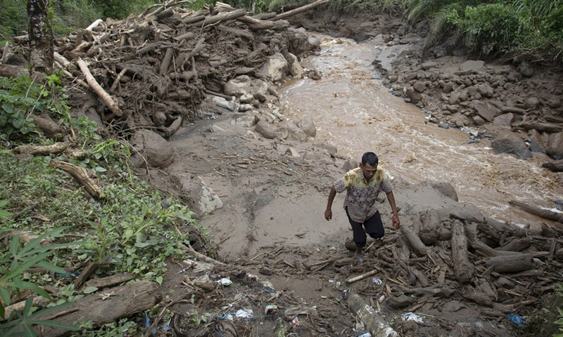 A man walks in the mud after floods triggered by heavy rains and rising waters of the Batang Nango river in Nagari Kajai village of Pasaman Barat district, West Sumatra, Indonesia, March 1, 2022.(Photo: Xinhua)