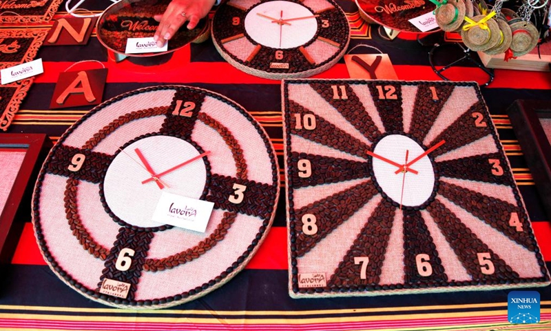 A woman displays her handmade clock panel decorated with natural coffee beans during a coffee-planting festival in Sanaa, Yemen, March 3, 2022.Photo:Xinhua