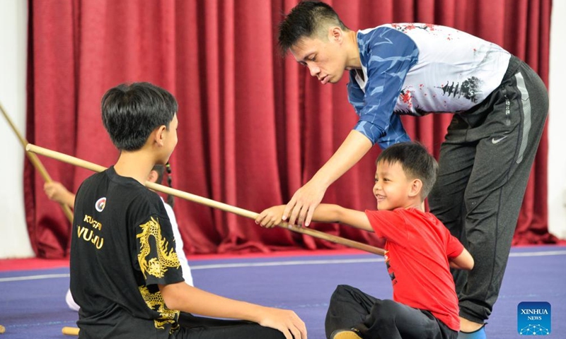 Gogi Nebulana (R), founder and martial arts coach of Harmony Wushu Indonesia, teaches children to practice martial arts at Harmony Wushu Indonesia in Bogor, Indonesia, March 5, 2022.Photo:Xinhua