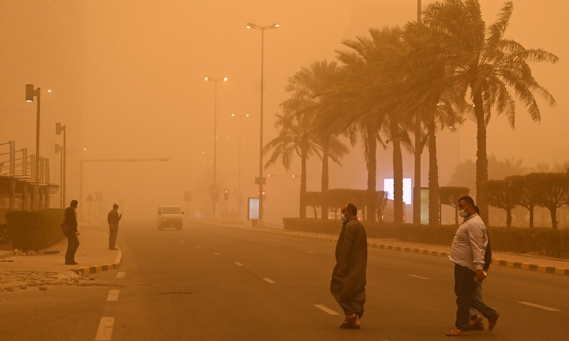 People walk on a street amid heavy dust in Kuwait City, Kuwait, March 4, 2022.(Photo: Xinhua)
