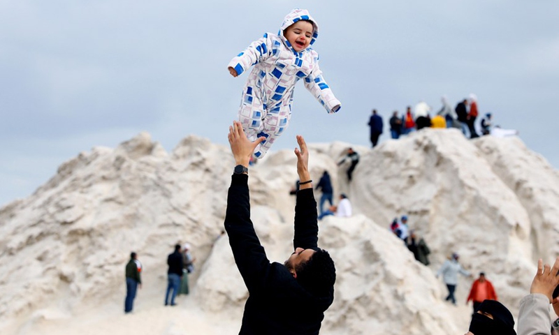 A father plays with his child on the salt mountains in Port Fouad, a city in Egypt's Port Said Governorate, on March 4, 2022.(Photo: Xinhua)