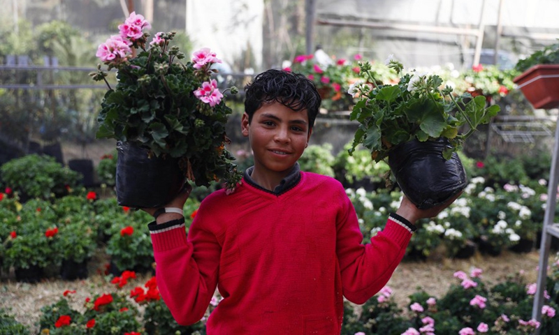 A boy shows flowers during the flora expo held in Giza, Egypt, on March 3, 2022.(Photo: Xinhua)