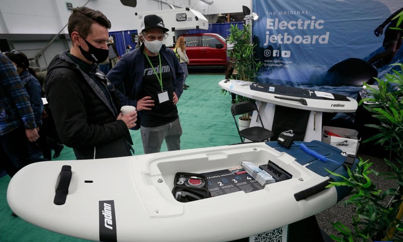People look at a electric powered surfboard at the Vancouver Outdoor Adventure and Travel Show in Vancouver, British Columbia, Canada, on March 5, 2022. The two-day event, which runs on March 5th and 6th, features the latest outdoor gear and information of adventure travel ideas.Photo:Xinhua