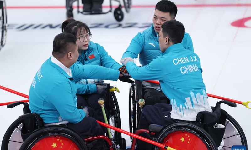 Wang Haitao, Yan Zhuo, Zhang Mingliang and Chen Jianxin (from left to right) of China cheer for each other during the Wheelchair Curling Round Robin Match between China and Canada of Beijing 2022 Paralympic Winter Games at National Aquatics Center in Beijing, capital of China on March 5, 2022. Photo: Xinhua/Xu Yanan