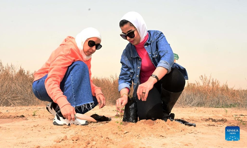 People plant seedlings during an environmental week in Jahra Governorate, Kuwait, March 6, 2022. The Environment Public Authority (EPA) of Kuwait launched on Sunday the environmental week to educate people about protection of the environment and natural resources in the country. The event will last until March 12. (Xinhua)