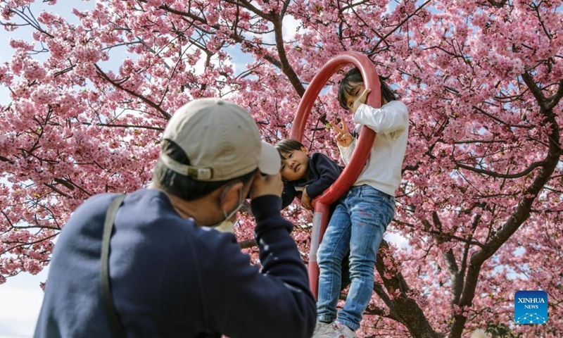 A man takes photos of children at the Nishihirabatake Park in Kanagawa, Japan, March 6, 2022. (Photo by Gong Xiuxi/Xinhua)