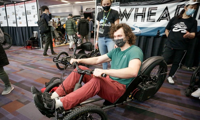 A resident tries to ride an electric tricycle at the BC Bike Show in Vancouver, British Columbia, Canada, on March 5, 2022.Photo:Xinhua