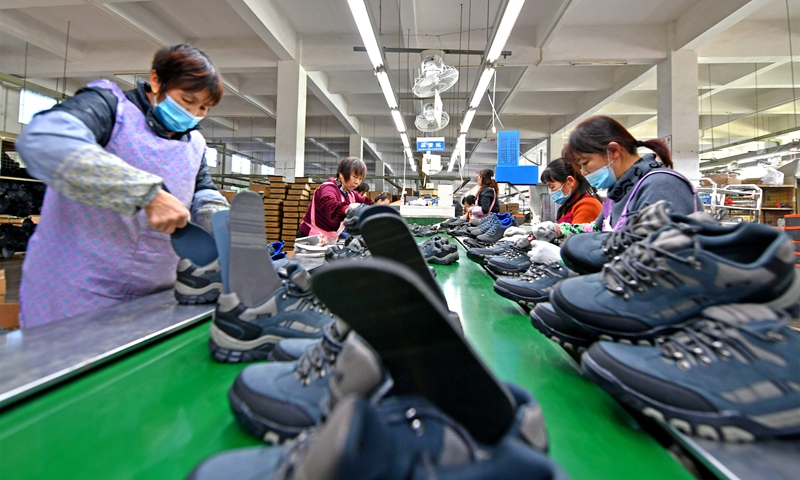 Workers work on an assembly line at a shoe factory in Quanzhou, East China's Fujian province on January 13, 2022. Photo: VCG