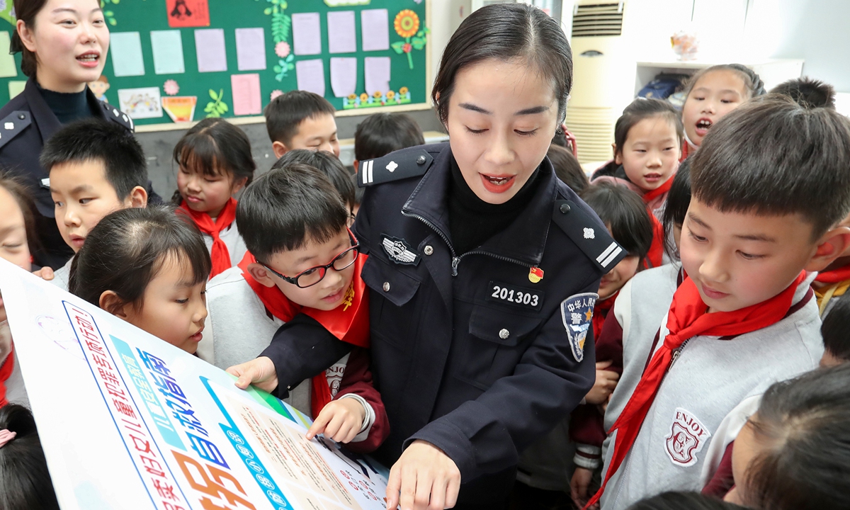 A female police officer promotes anti-trafficking information to students in an elementary school in Wuxi, East China's Jiangsu Province on March 7, 2022. Photo: VCG