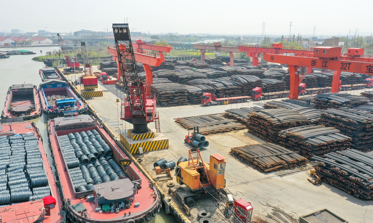 Employees work in the logistics area at a steel base in Xin'an town, East China's Zhejiang Province, on March 24, 2022. The base integrates production, stockpiles and transport. Daily steel throughput averages 10,000 tons. Located beside the Jiangnan Canal, which joins the Yangtze River, shipments from the base can reach 16 major cities in the Yangtze River Delta. Photo: cnsphoto