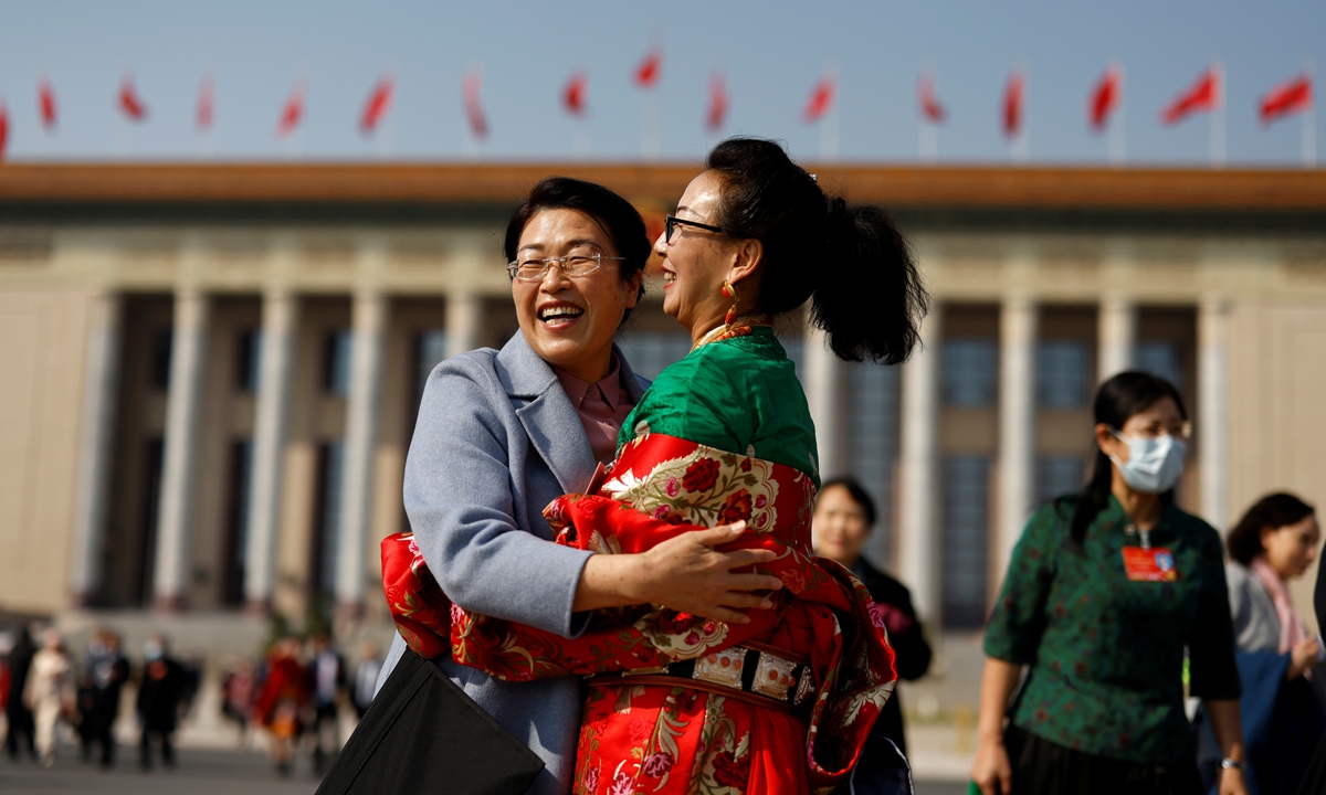Delegates embrace outside the Great Hall of the People to celebrate the International Women's Day after the second plenary meeting of the fifth session of the 13th National People's Congress in Beijing on March 8, 2022.