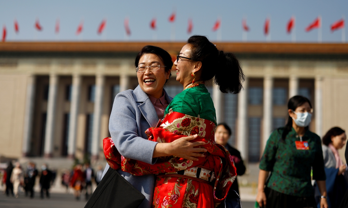 Delegates embrace outside the Great Hall of the People after the second plenary session of the National People's Congress (NPC) in Beijing,on March 8, 2022.Photo: IC