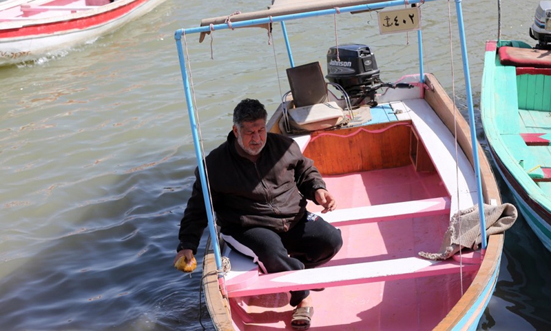 A worker cleans a wooden boat to transport passengers between the banks of the Tigris River in Baghdad, Iraq, on March 4, 2022. (Photo: Xinhua)