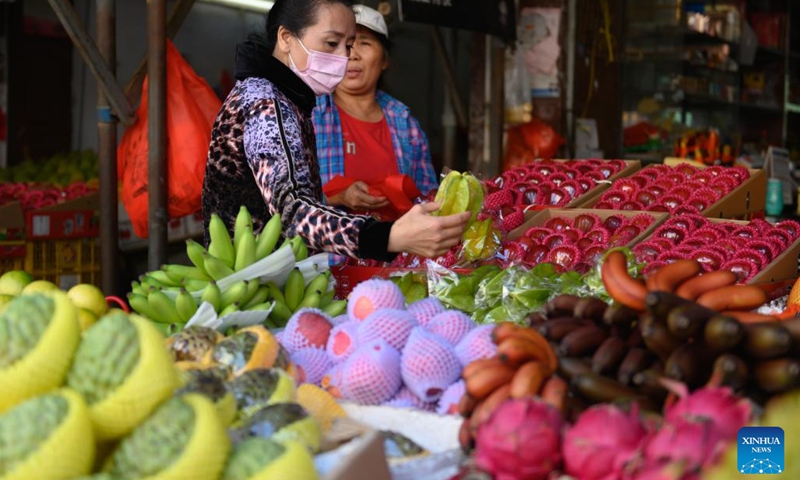A customer selects fruits at a local market in Haikou, south China's Hainan Province, March 8, 2022. (Photo: Xinhua)