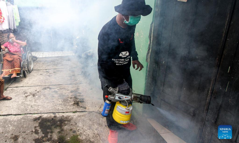 A worker sprays anti-mosquito fog to prevent the spread of dengue fever at a residential area in Surakarta, Central Java, Indonesia, March 10, 2022. (Photo by Bram Selo/Xinhua)
