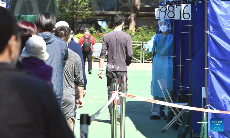 People wearing face masks line up for nucleic acid testing for COVID-19 at a mobile testing site at Victoria Park in Hong Kong, south China, March 8, 2022. The Hong Kong Special Administrative Region (HKSAR) reported 28,475 new COVID-19 cases on March 8. (Xinhua/Lo Ping Fai)